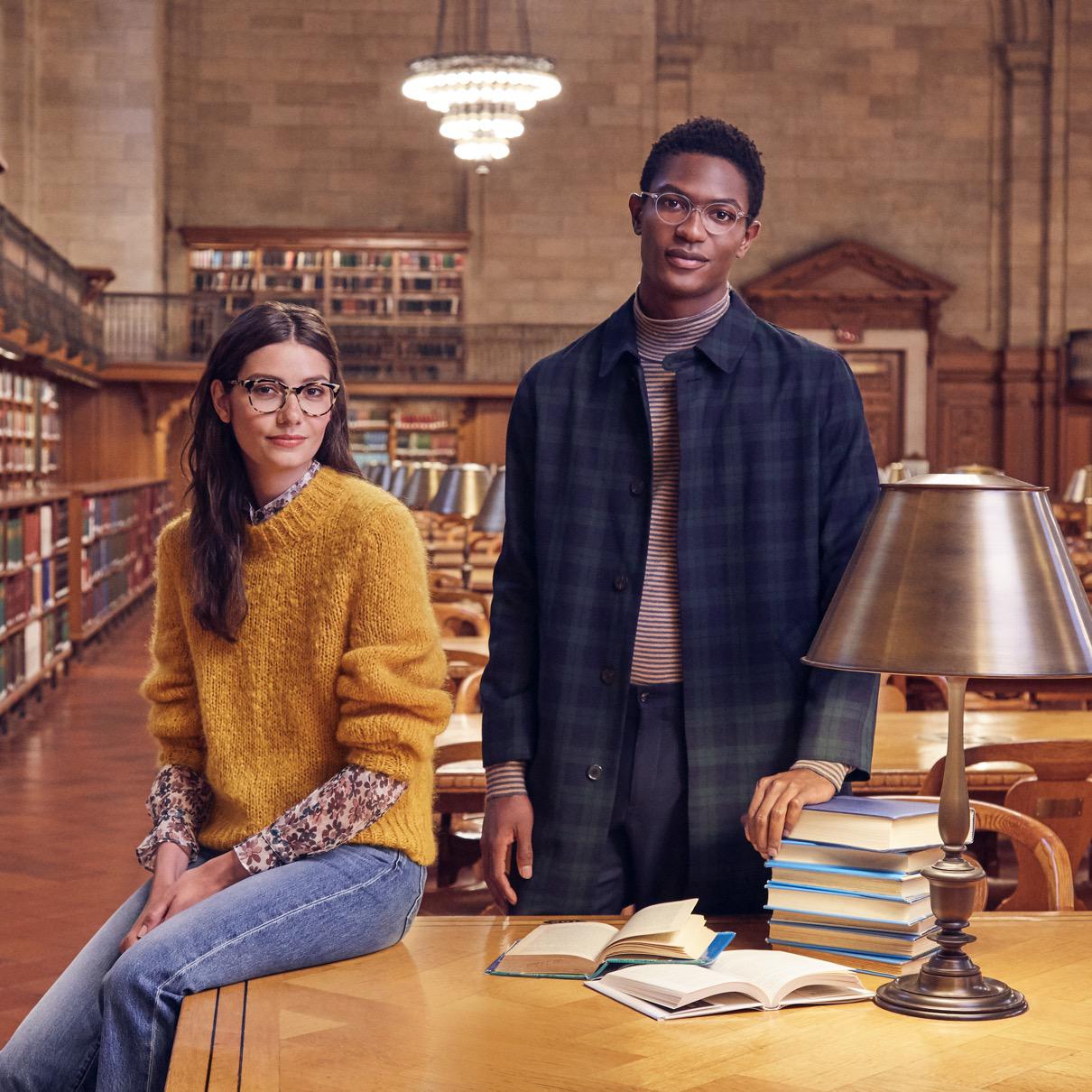 two people in New York Public Library wearing Warby Parker glasses